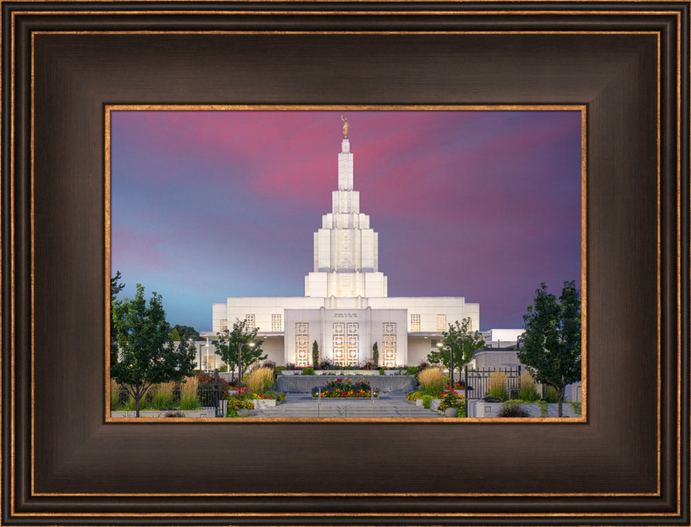 Idaho Falls Temple shining bright against a deep purple sky.