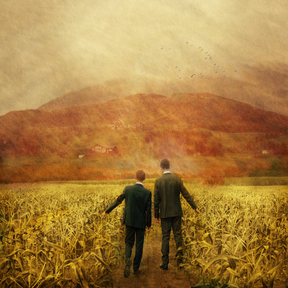 Two missionaries walk down a field of grain.