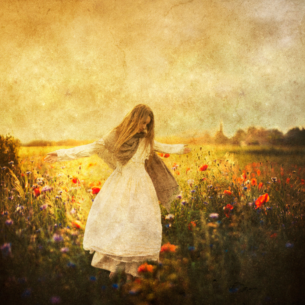 A girl in a white dress in a field of flowers.