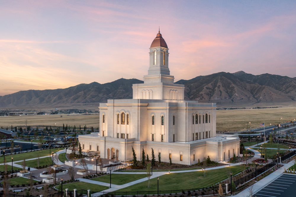 The Deseret Peak Utah Temple at sunset with the mountains.