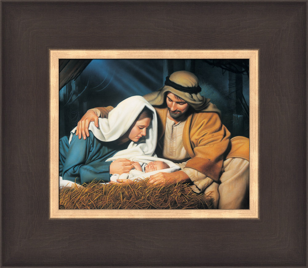 Joseph and Mary look at baby Jesus as he sleeps in the manger.