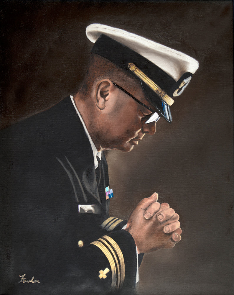 A Navy chaplain bowing his head in prayer.