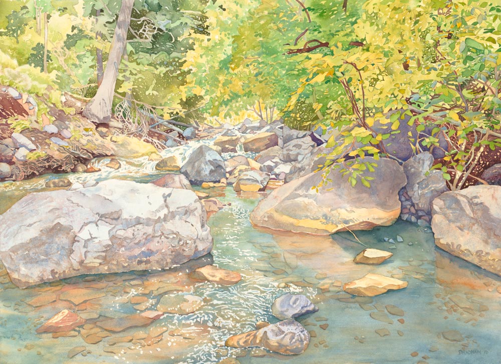 Watercolor landscape of a mountain stream with trees and big rocks.