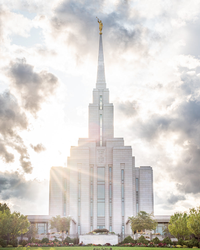 Front View of Oquirrh Mountain Temple with light shining from behind.