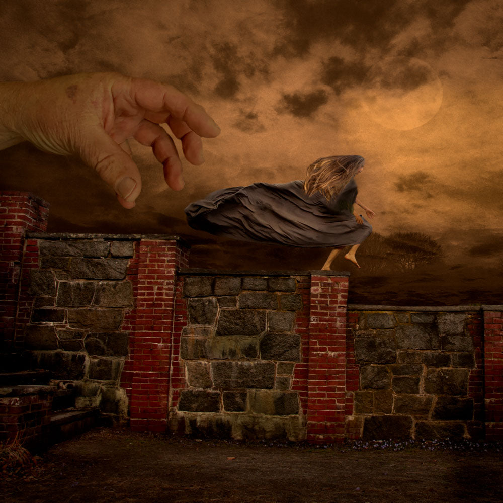 A girl runs across a wall through the fog as a large hand reaches for her.