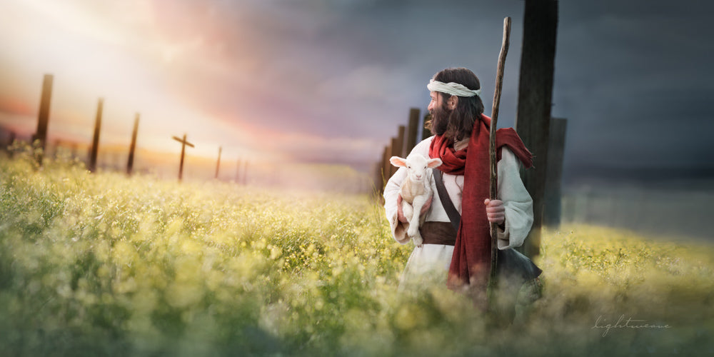 Jesus holding a lamb looking back at a cross.