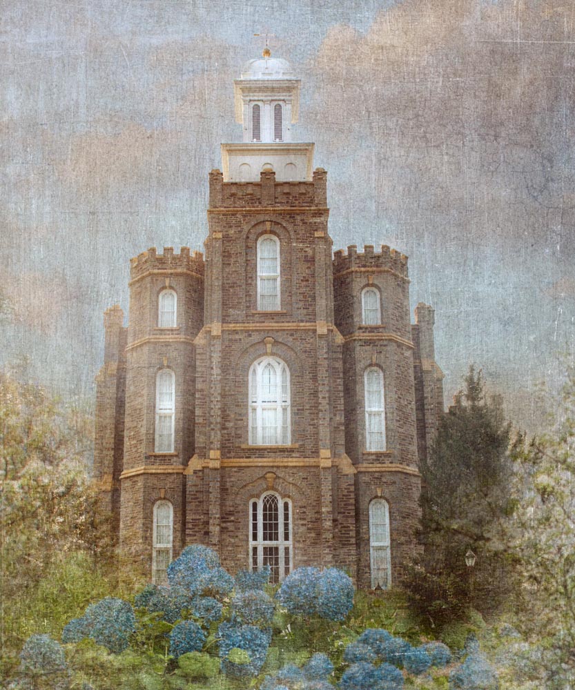 Logan Utah Temple with blue flowers in front.