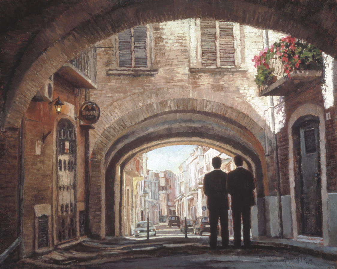 Two elder missionaries walking under an arch in a European Street.