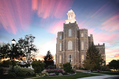 The Logan Utah Temple at sunset with pink clouds.