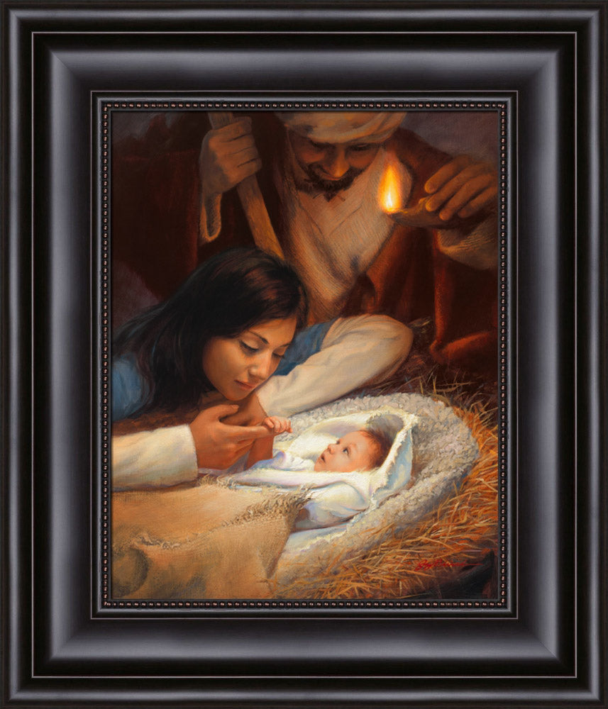 Mary holding baby Jesus' hand with Joseph watching over the manger scene