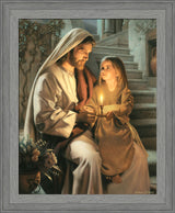 Jesus holding a girl and sharing a candle that is lighting their faces.