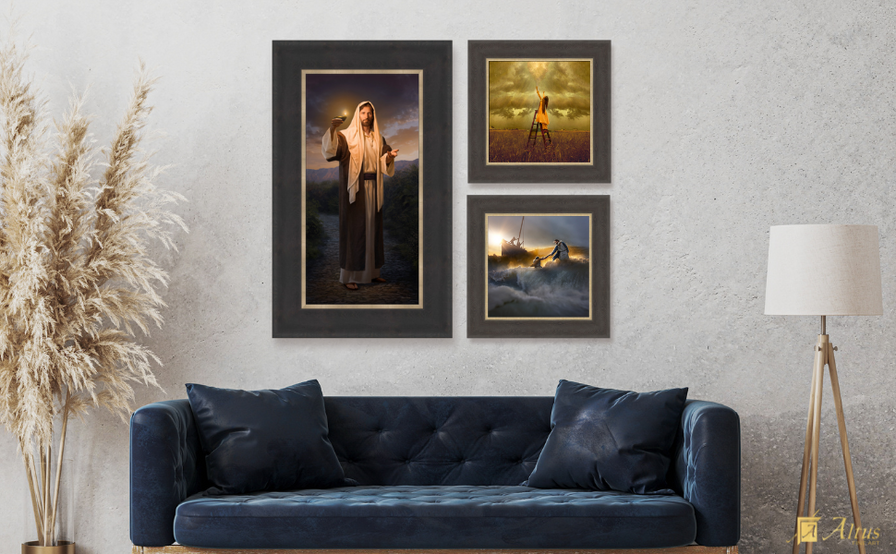 A living room with a navy blue couch showcasing framed religious artwork, including an image of Jesus holding a lamp, placed on a textured wall.