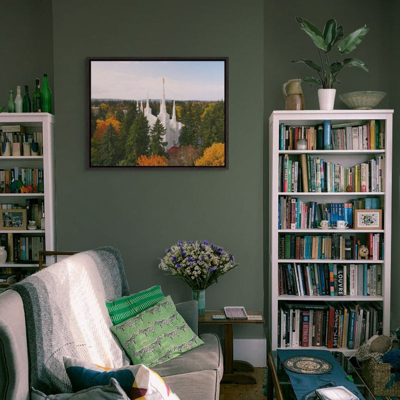 Living room with a gray armchair, bookshelves, and Altus Fine Art painting on the wall.