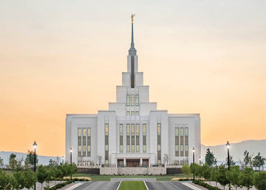 The Saratoga Springs temple with a yellow sunrise background.