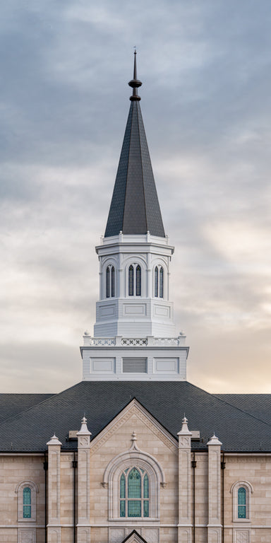The spire of the Taylorsville Utah Temple with a cloudy sky.