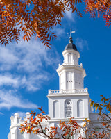 The St. George Utah Temple with fall foliage and a blue sky.