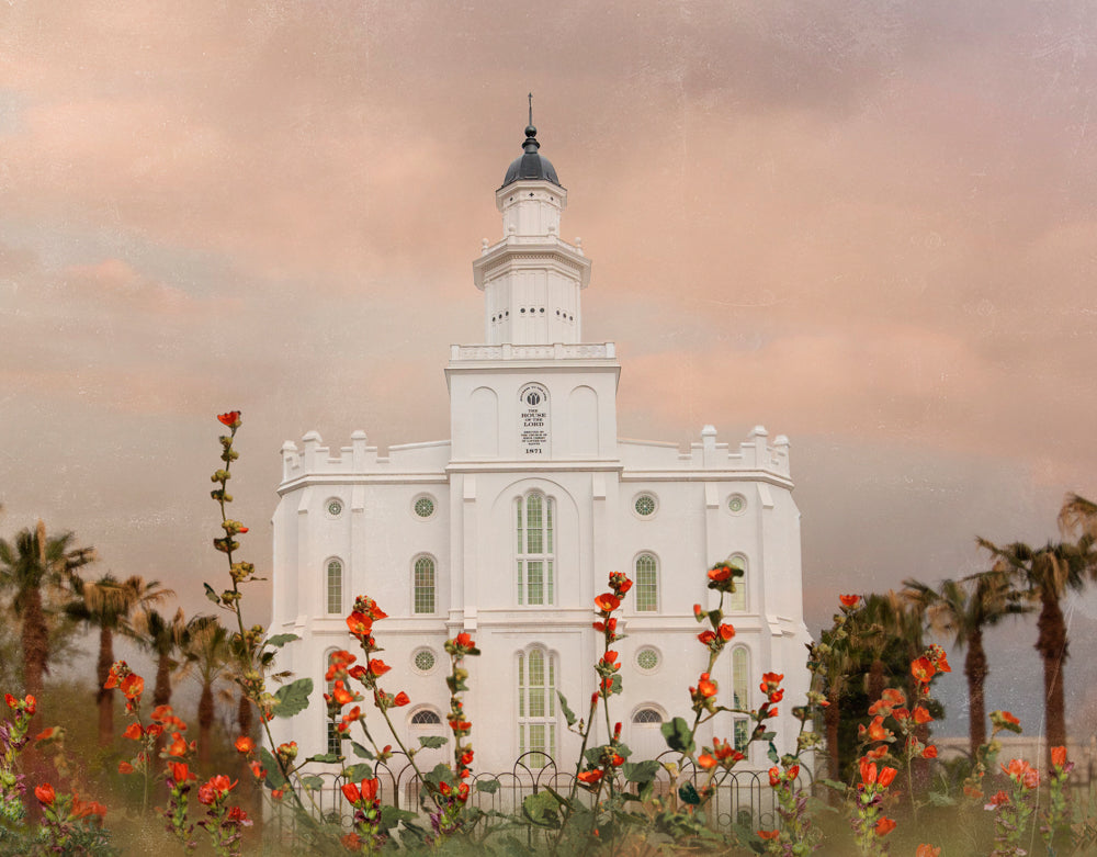 The St. George Utah temple with red flowers.