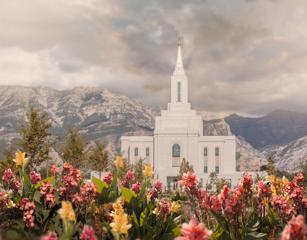 The Orem Utah Temple with mountains and flowers.