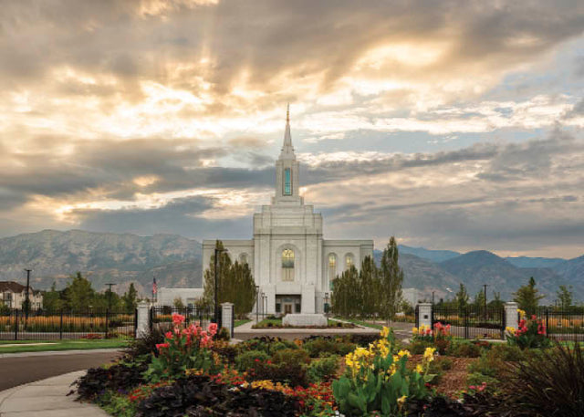 The Orem Utah Temple with light shining through the clouds.