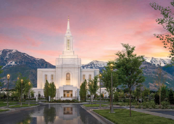 The Orem Utah Temple with mountains and a sunset sky.