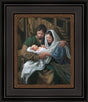 Mary and Joseph hold baby Jesus in the stable.