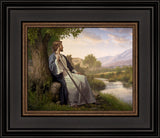 Jesus resting against a tree looking out over a small stream and valley.