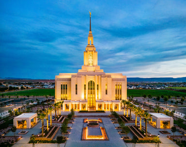 The Red Cliffs Utah Temple lit up in the evening.