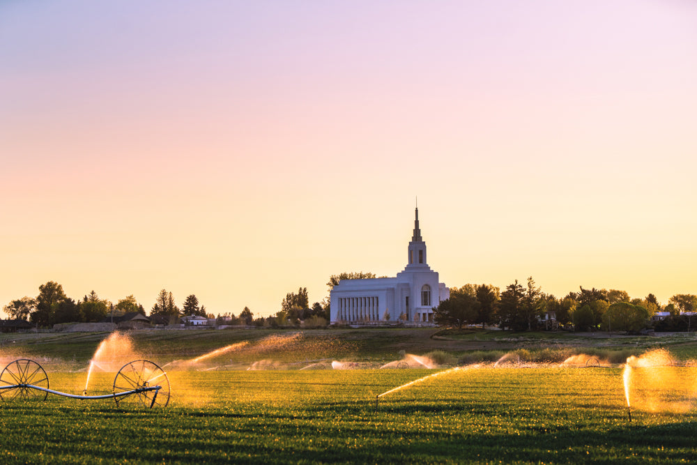 The Burley Idaho Temple with sprinklers and a field.