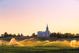 The Burley Idaho Temple with sprinklers and a field.