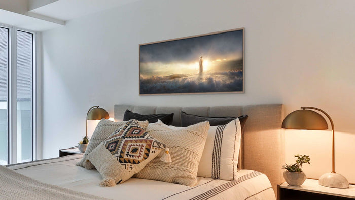 Modern bedroom with a bed, decorative pillows, and a wall painting of a lighthouse.