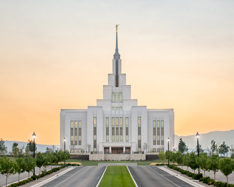 The Saratoga Springs temple with a yellow sunrise background.