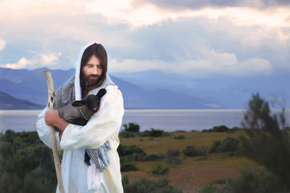 Jesus carrying a black lamb. Mountains and fog fill the sky.