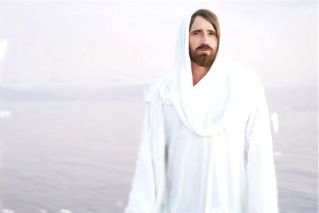 Whited-out image of Jesus standing in front of a body of water.