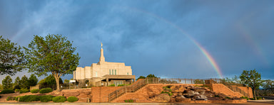 Distant photo of the Snowflake Temple on a hill. Two rainbows arch over it.