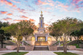 The sun rises behind the San Antonio Temple. Golden light pours from its windows.