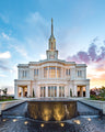 Photo of the Payson Temple with a focus on a flowing water fountain. The sun is setting in the background.