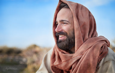 Profile portrait of jesus smiling with red shawl on head.