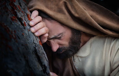 Jesus in gethsemane leaning against tree suffering. 