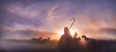 Shepherds sitting in a field at sunrise.
