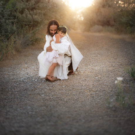 Jesus Christ hugging a little girl.