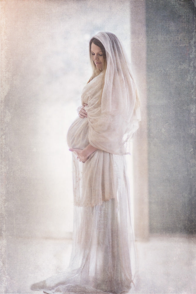 Marry wearing all white holding her pregnant belly. 