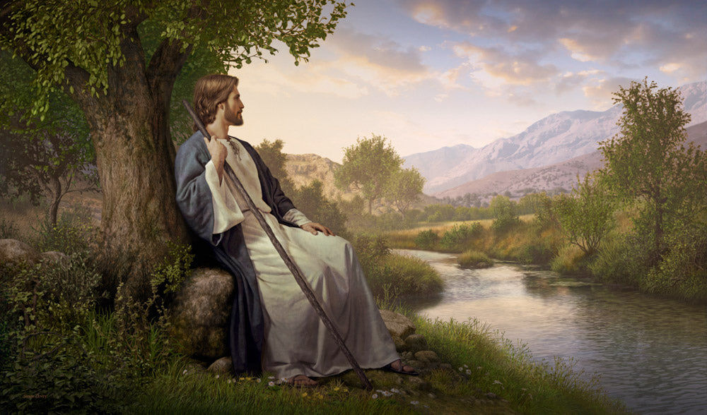 Jesus resting against a tree looking out over a small stream and valley.
