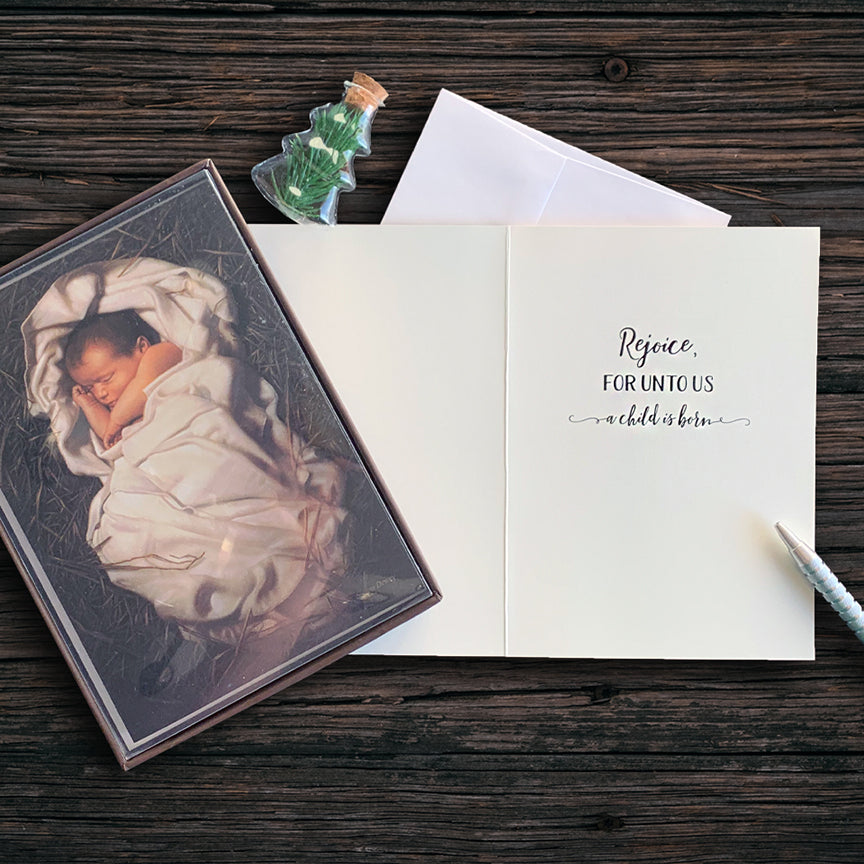 Boxed Christmas cards featuring baby Jesus in a manger with ‘Rejoice, for unto us a child is born’ inscription.